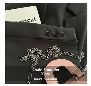 Detail of pink cylinder bag with silver metal chain strap and sleek leather handle