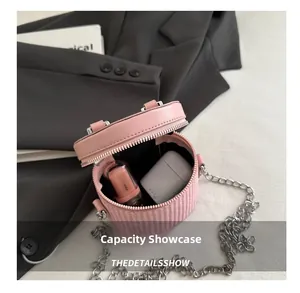 Internal capacity of pink woven cylinder bag showing lip gloss and earphones
