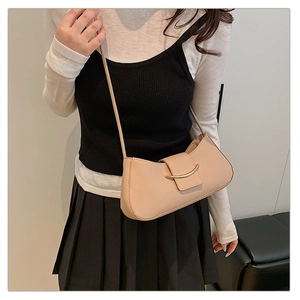 Detail showing a beige French vintage underarm bag worn by a model in a minimal setting
