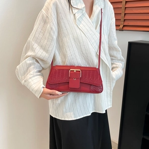 Sac à épaule rouge texture crocodile avec boucle dorée et silhouette baguette élégante