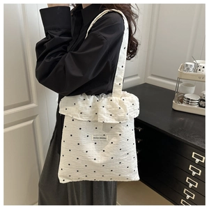 Détail du sac cabas en mousseline florale avec bords volantés et étiquette tissée