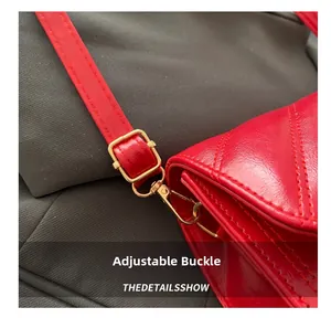 Vue détaillée de la bandoulière en cuir verni rouge avec boucle de réglage dorée