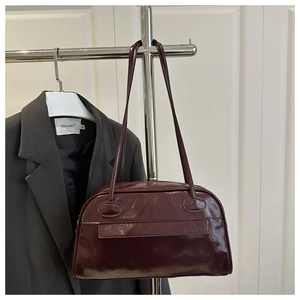 Detailaufnahme der dunkelroten, glänzenden Lackledertextur der Boston-Schultertasche