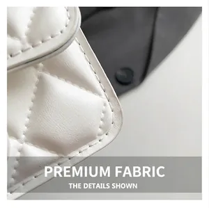 Detailed macro view of white quilted leather texture with premium stitching on small bag