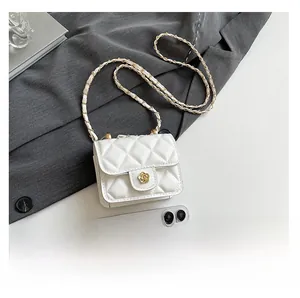 Mini quilted white crossbody bag with golden camellia buckle next to a smartphone