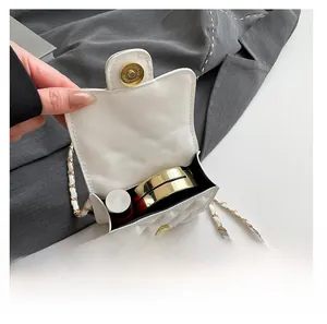 Detail of the compact interior capacity of the white quilted mini chain bag