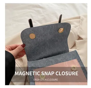 Detail of metal magnetic buckles on contrast color bag with suede lining