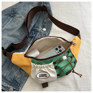 Détail du sac bandoulière tricolore montrant l'intérieur spacieux pour téléphone et écouteurs