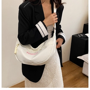 Close-up of white crescent crossbody bag with pink fashion lettering and rope detail