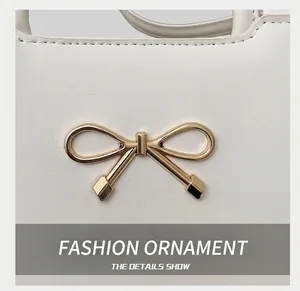 Vue détaillée du cuir blanc avec un nœud en métal doré raffiné sur le sac à main