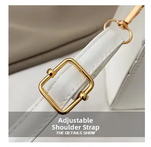 Détail de la bandoulière réglable sur sac en cuir blanc avec boucle dorée en métal
