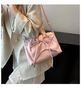 Détail du sac cabas rose avec un grand nœud et des boucles métalliques argentées