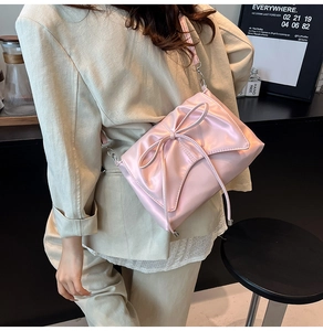 Détail du sac en satin rose avec un nœud élégant et des plis texturés raffinés