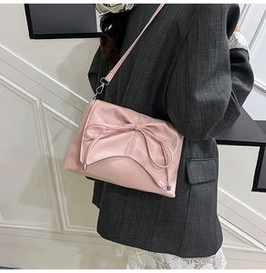 Détail du sac à bandoulière en cuir PU rose avec un grand nœud décoratif et boucles argentées