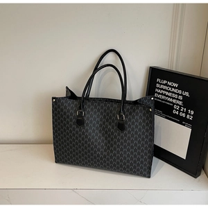 Détail du grand sac cabas avec motif M blanc et finitions luxueuses dorées