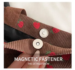 Detail of the magnetic snap closure on the strawberry print corduroy tote bag