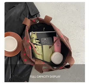 Brown corduroy tote bag showing large capacity for umbrella, tablet and wallet