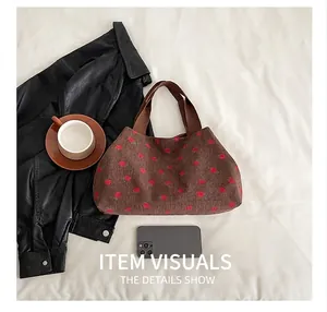 Detail of brown corduroy tote bag with red strawberry print and sturdy ribbon handles