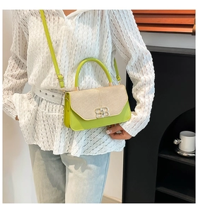 Detail shot of the green leather handbag featuring a beige woven texture flap and silver BB logo