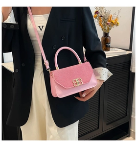Detail of pink PU leather handbag with sparkling fabric and gold double-B buckle closure