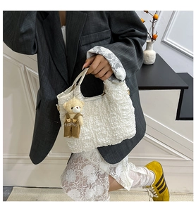 Detail view of white bubble texture tote bag featuring a cute bear plush pendant