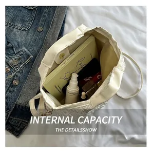 Spacious interior of white pleated bucket bag showing cosmetics and an A5 notebook