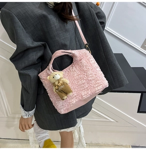 Detailed side view of pink ruched bucket bag with cute bear charm and leather strap