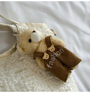 Détail du sac à main plissé blanc avec charm ours en peluche et tenue en velours côtelé