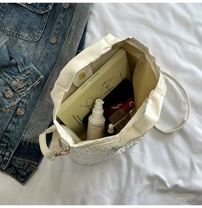 Détail de l'intérieur d'un sac seau perlé blanc avec fermoir magnétique et rangement
