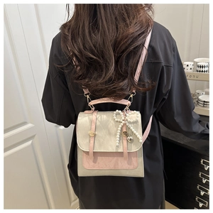 Détail du sac à dos patchwork gris-rose avec nœud en perles et pendentif cœur en métal