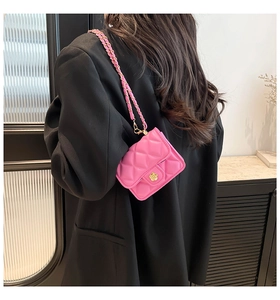 Rear view of model wearing a pink quilted mini chain bag with gold flower buckle detail