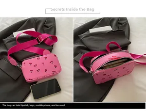 Detail view of pink cherry print crossbody bag showing interior capacity and compartments