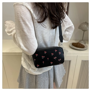 Fashionable black crossbody saddle bag with red cherry prints and wide nylon shoulder strap
