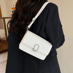 Minimalist white leather square shoulder bag with silver buckle worn by a model