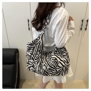 Détail du grand sac cabas à motif zèbre porté à l'épaule pour un style quotidien