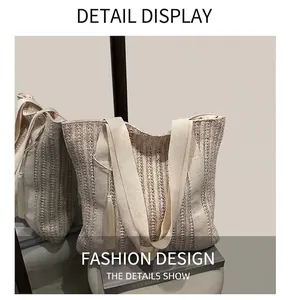 Detail of woven straw tote bag featuring stylish fringe tassel and canvas shoulder strap