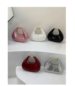 Close-up of stylish mini crescent handbags in five glossy colors on a white display stand