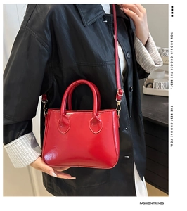 Detail of red patent leather mini bag with high-gloss finish and slim shoulder strap