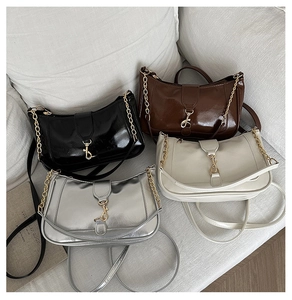 Detail of trendy crescent shoulder bags in black, coffee, cream and silver with gold chains