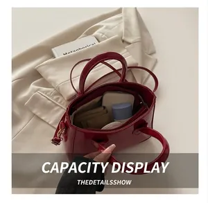 Interior view showing the storage capacity of the glossy burgundy leather handbag