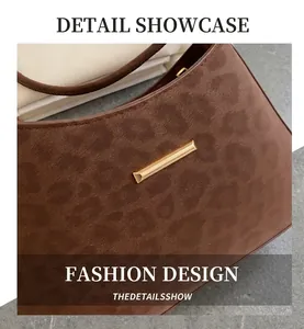 Detail of brown suede leopard print handbag featuring a polished gold metal bar accent