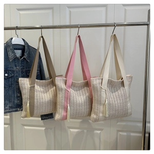 Detailed texture of woven straw tote bags in khaki pink and cream with fringe tassels