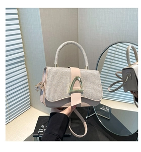 Detail of the pink crossbody bag with a sparkling textured flap and gold metal buckle