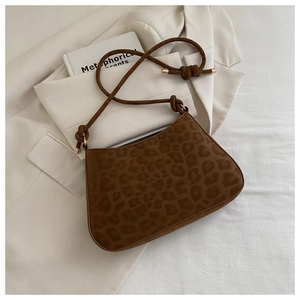 Close-up of leopard print shoulder bag with elegant knot strap and gold metal accents