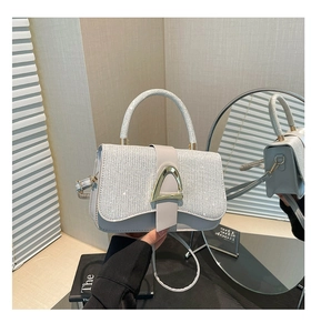 Close-up of silver glitter crossbody bag with gold triangle clasp and mirror reflection