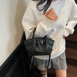 Elegante borsa tote in pelle intrecciata nera con tracolla indossata da modella