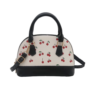 Stylish shell handbag with red cherry print, cream body and black handles for daily commuting