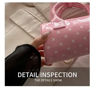Close-up of pink polka dot barrel handbag showing detailed stitching and glossy finish
