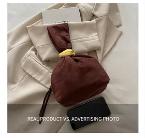 Vue détaillée du sac à main en daim marron avec anneau doré et détail de fermeture