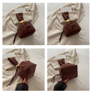 Vues détaillées du sac seau en daim marron avec d'élégants accents métalliques dorés